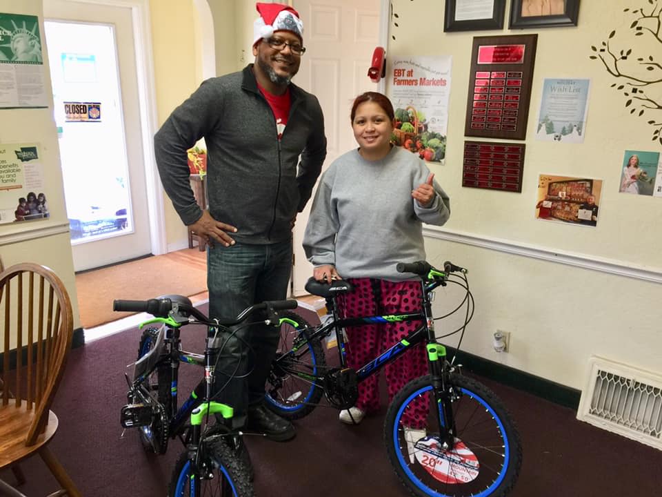 Chris gives a client two boy's bikes for her sons.