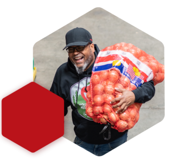 image of staff member carrying bag of onions