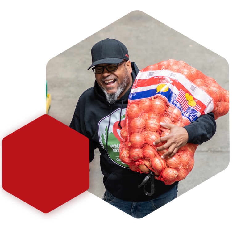 image of staff member carrying bag of onions